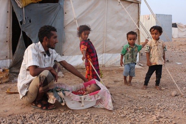 A Yemeni man proudly watching over a young baby in a refugee camp in Obock, Djibouti. Credit: James Jeffrey/IPS