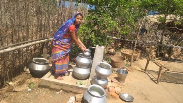 Simita Devi, whose daughter spent days in hospital recently suffering from typhoid caused by contaminated water, collects clean water brought to the surface by a solar pump. Credit: Umar Manzoor Shah/IPS