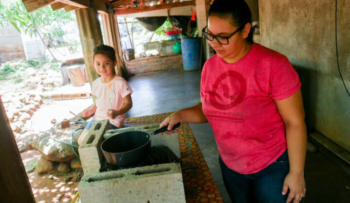  Marleni Menjivar gets ready to heat water on her ecological stove, watched closely by her four-year-old daughter, in El Corozal in central El Salvador, where an innovative government program to produce biogas has arrived. With this technology, people save money by buying less liquefied gas while benefiting the environment. CREDIT: Edgardo Ayala / IPS
