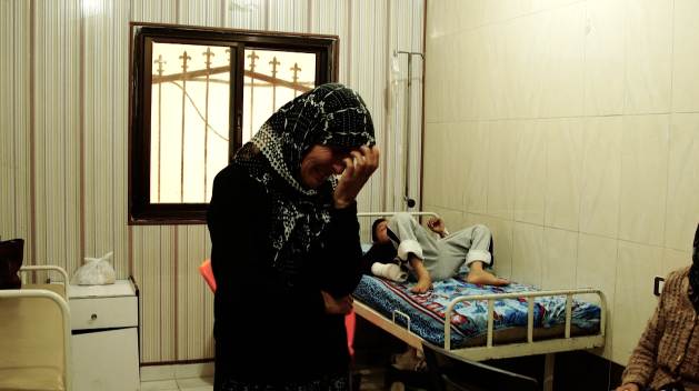 Bir kadın ve yaralı oğlu, Afrin'in işgalinden sonra inşa edilen derme çatma hastanede bekliyor.  Artık topraklarına yerleştirilen Arap yerleşimciler, diğerlerinin yanı sıra Filistin fonları tarafından finanse edilen hastanelere erişime sahip.  Kredi bilgileri: Jewan Abdi/IPS 