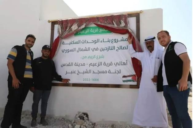 At the opening of the Al Zaim settlement. &amp;quot;Shelter units project for displaced persons from northern Syria funded by Al Zaim donations, in Quds Town,&amp;quot; reads the panel. Image: Ajnadin's social media 