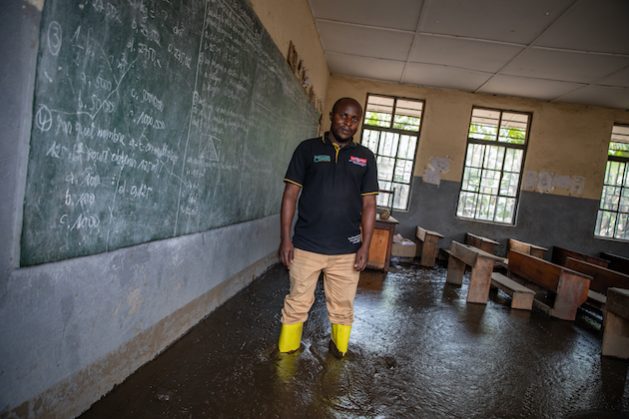 Patient Kyahi, principal of Sake Elementary School, in front of the blackboard in his mud-filled classroom in Sake, a village located 27 km from the city of Goma, North Kivu province in DRC. Credit: Sibylle Desjardins / Climate Visuals