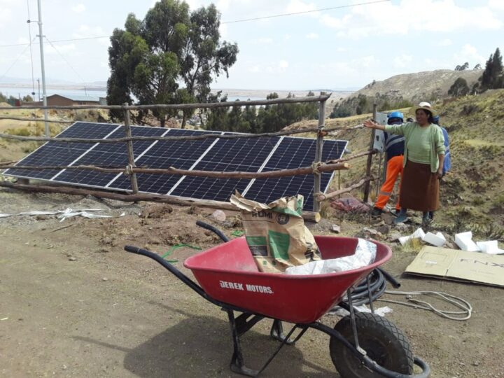 Pumps fueled by 180-watt solar panels draw water from rustic wells to irrigate vegetable crops in the highland greenhouses of Peruvian farming communities. In the picture, farmer Fermina Quispe is helping to move the solar panels. CREDIT: Courtesy of Fermina Quispe