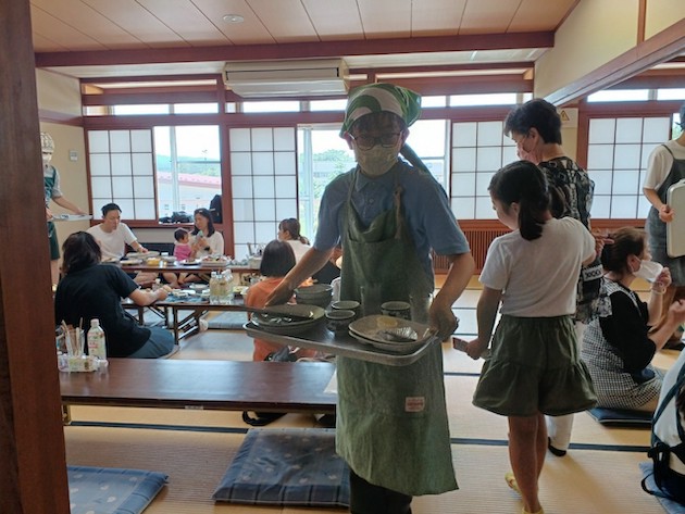 A student from Dalton Tokyo Junior assists with serving at Watashi kitchen at Karuizawa.