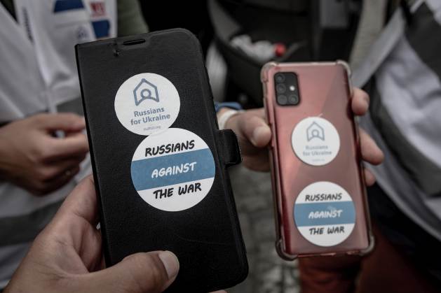 Des téléphones portables entre les mains de Russes en exil travaillant bénévolement à la frontière polono-ukrainienne.  L'invasion de l'Ukraine par Moscou a également entraîné une escalade des menaces contre les journalistes russes.  Crédit : Gilad Sade/IPS