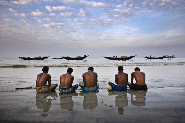 Five fishers pray for a benevolent sea in Dublar, Bangladesh. Credit: Rodney Dekker/Climate Visuals