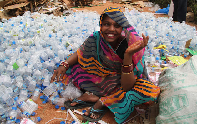 A woman sits among the plastic waste which will be recycled several times. Credit: Go Rewise