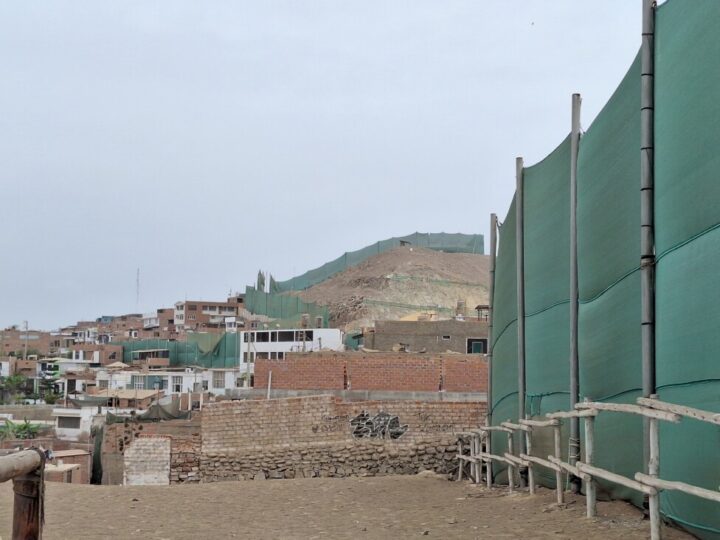 Green shading net runs through different areas of the Peruvian port town of Chancay. It is the division between the work zone of a mega-port and the homes of the local population, affected by dust, seismic waves from the explosions, tension and noise. CREDIT: Mariela Jara / IPS