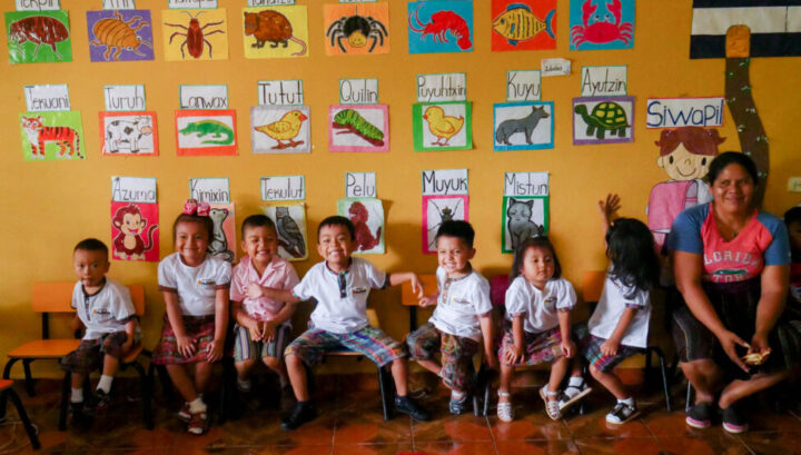 عکسی از برخی از کودکانی که در شهر ناهویزالکو، در غرب السالوادور، از طریق یک برنامه غوطه وری زبان اولیه در دانشگاه دون بوسکو در تلاش برای زنده نگه داشتن زبان در خطر انقراض، ناهواتل را یاد می گیرند.  معلم السا کورتز کنار آنها می نشیند.  اعتبار: ادگاردو آیالا / IPS