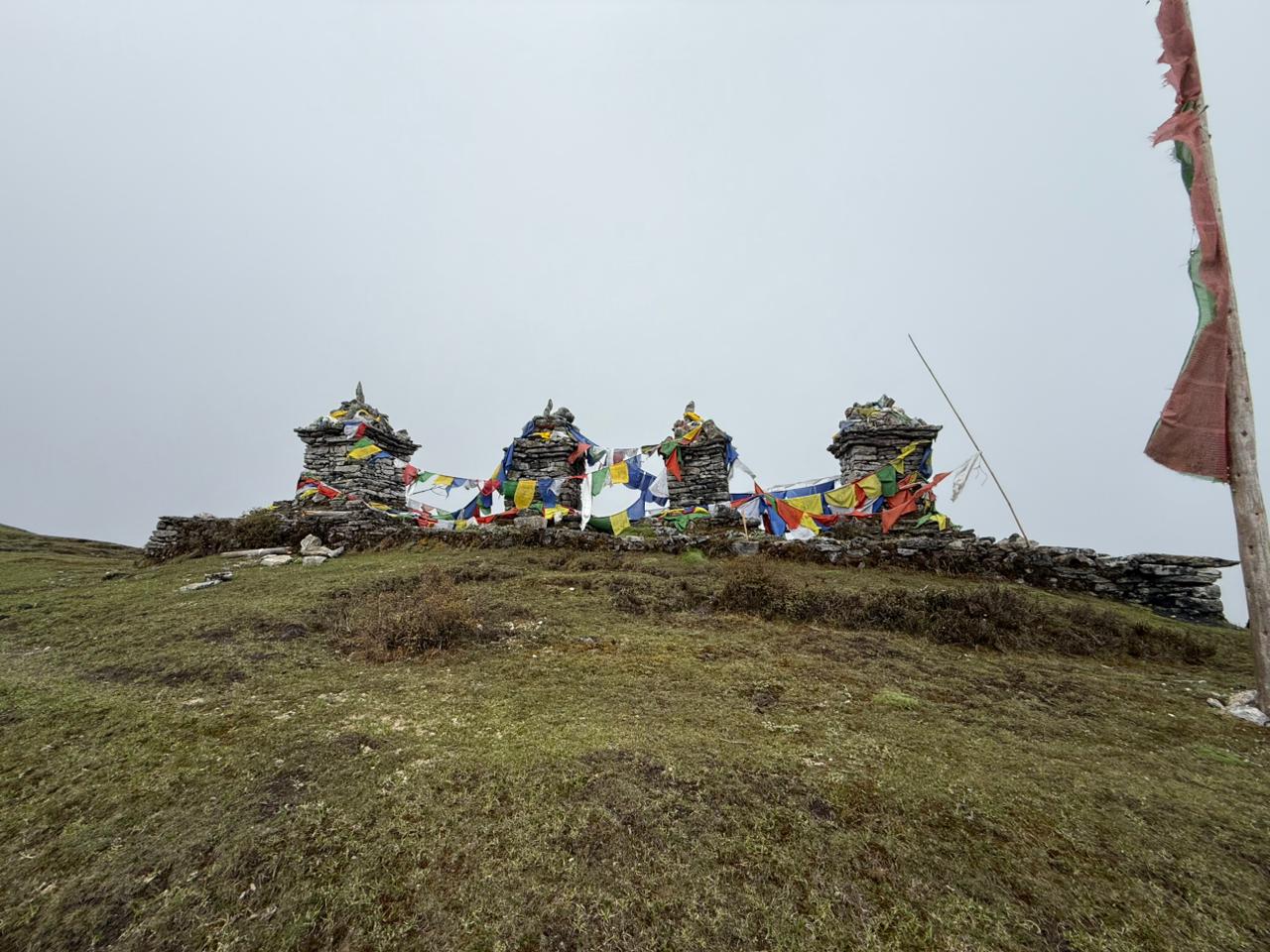 Buddhist stupas covered in flags serve as a spiritual landmark on high-altitude trekking trails, such as those leading to Mount Kanchenjunga. Credit: Shering Uden, KCC
