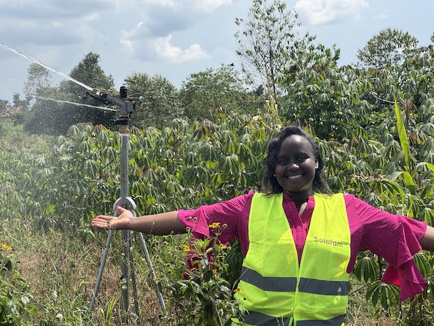 Shifra Ainomugisha poses beside a solar-powered irrigation system in Uganda. She was named the 2026 Commonwealth Young Person of the Year. Her contribution includes combining renewable energy and AI-enabled agricultural support to help smallholder farmers increase productivity and reduce post-harvest losses. Credit: Solar Farm Uganda