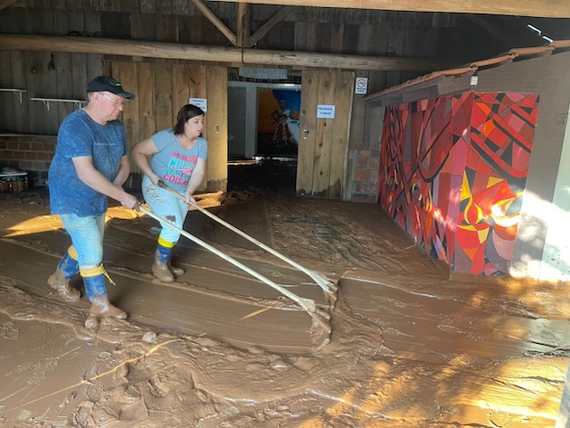 Iyá Patrícia d’Xangô (Mãe Patrícia) and her husband, Ogan Cézar d’Oxalá (Cézar Paulo Fogolari), cleaning their religious site three months after the mudslide in 2024.